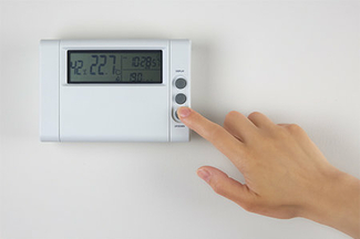 Écran numérique pour le réglage du chauffage sur un mur blanc dans la pièce à vivre